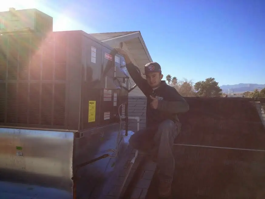 HVAC technician performing Air Duct Repair on a rooftop unit in Washington